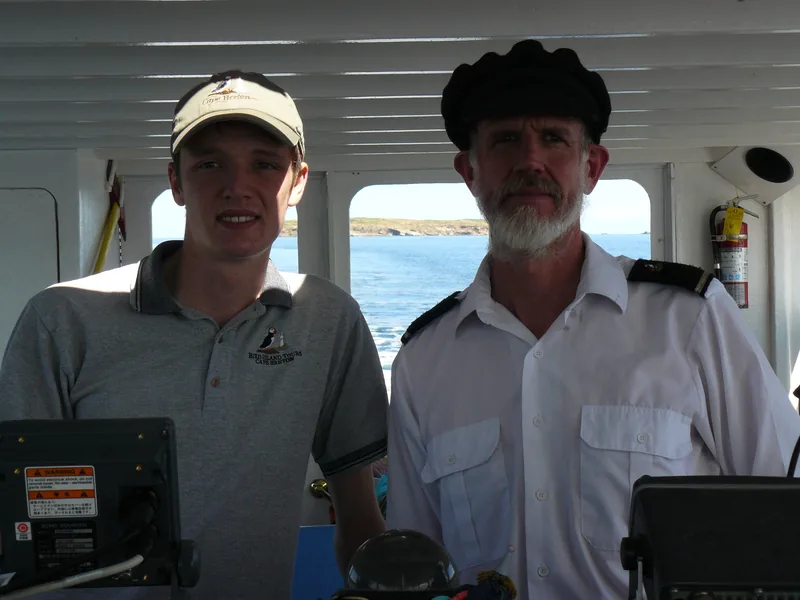 Captain Ian standing next to Captain Vince at the helm of the Puffin Express boat in 2010