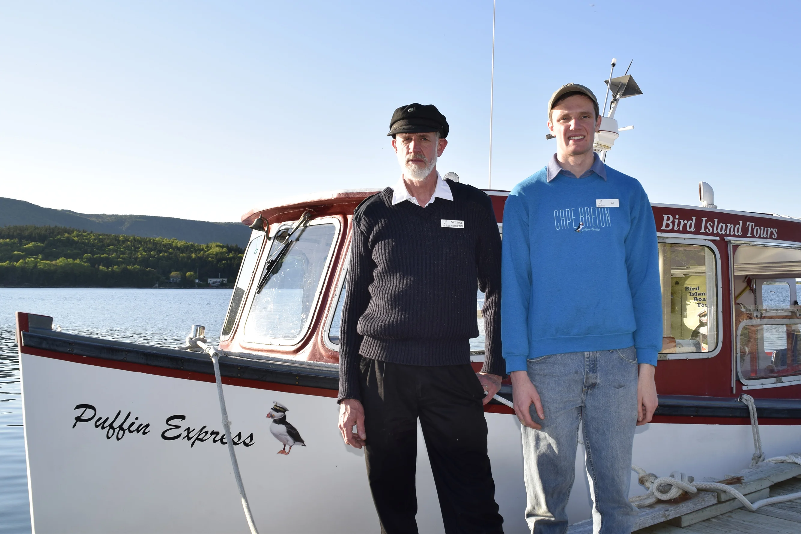 Captain Vince & Captain Ian standing at the helm station on the Puffin Express boat in 2016