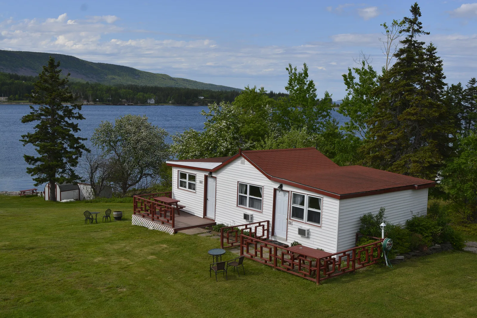 The outside view of Cottage 3, showing the green grass and blue ocean view